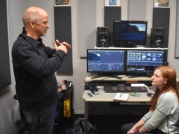 John Nelson talks with SAC senior Annie Cohen in the SAC editing room